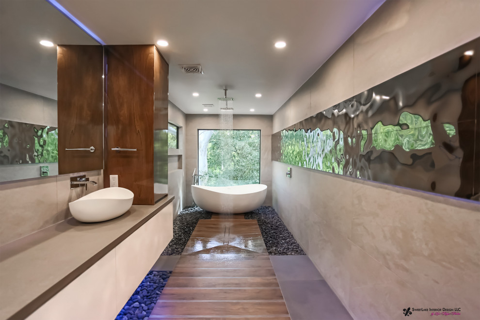 Modern inredning av ett stort badrum, med ett fristående badkar, en öppen dusch, en vägghängd toalettstol, klinkergolv i småsten, ett fristående handfat och med dusch som är öppen