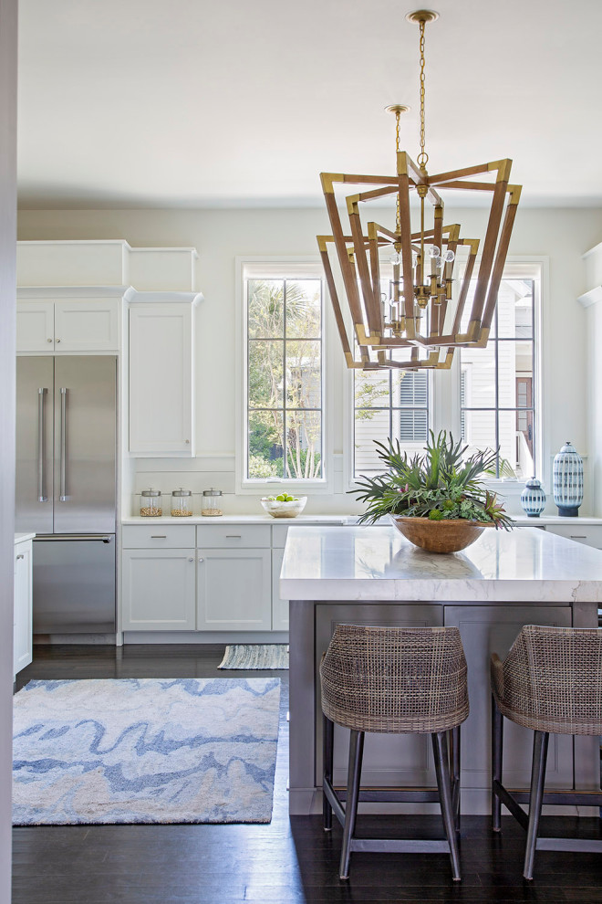 Example of a transitional l-shaped dark wood floor and brown floor kitchen design in Charleston with shaker cabinets, white cabinets, stainless steel appliances, an island and white countertops