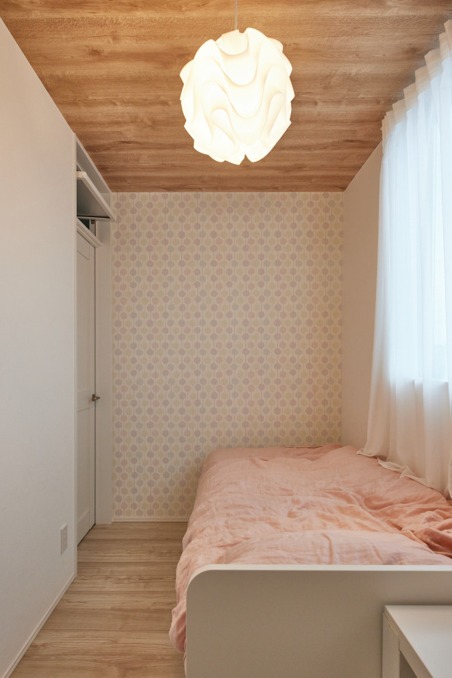 Cette photo montre une petite chambre d'enfant moderne avec un mur blanc, un sol en contreplaqué, un sol beige, un plafond en papier peint et du papier peint.