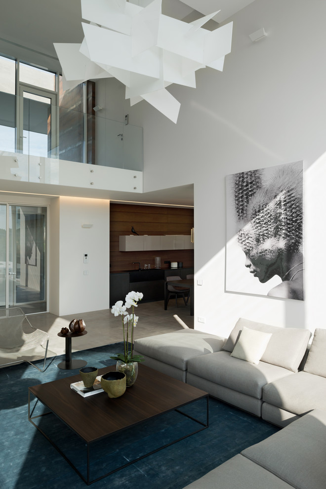 Diseño de salón para visitas abierto grande con paredes blancas, suelo de baldosas de porcelana y televisor colgado en la pared