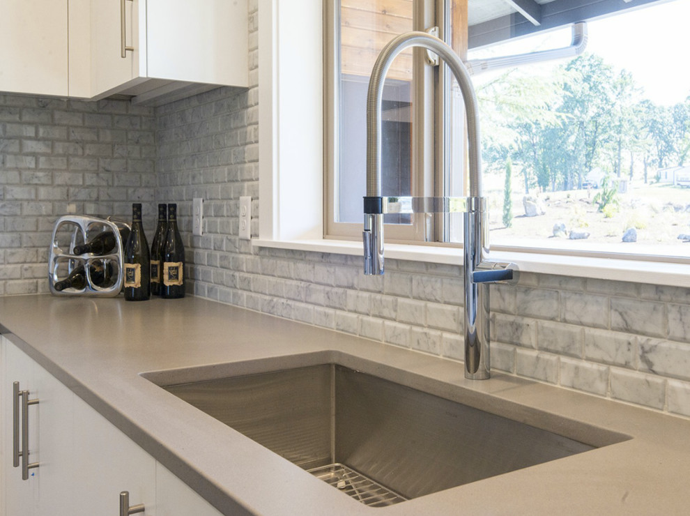 Inspiration for a small transitional u-shaped eat-in kitchen in Portland with an undermount sink, flat-panel cabinets, white cabinets, grey splashback, stone tile splashback, stainless steel appliances, dark hardwood floors, a peninsula and quartzite benchtops.