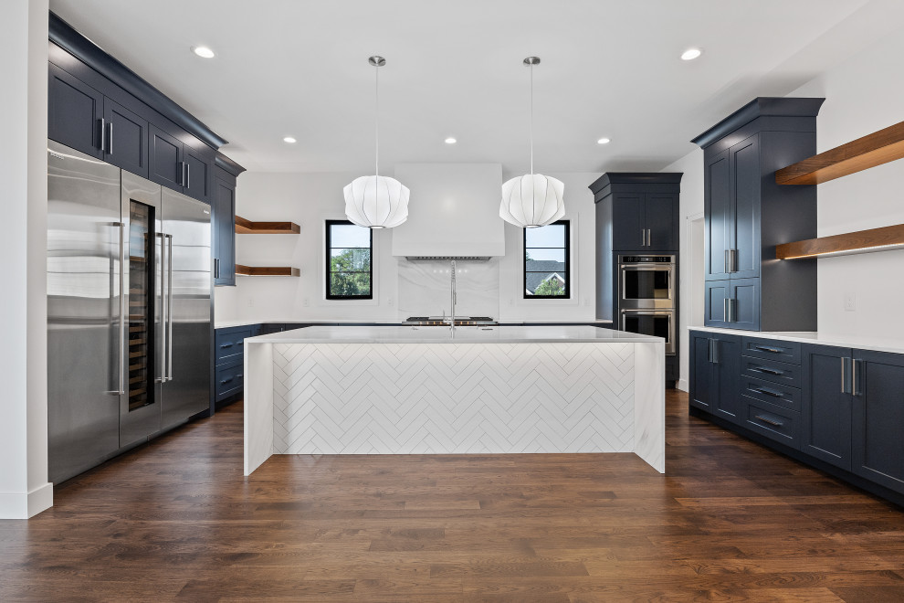 Inspiration for a modern dark wood floor and brown floor kitchen pantry remodel in Cedar Rapids with a single-bowl sink, recessed-panel cabinets, blue cabinets, quartz countertops, white backsplash, quartz backsplash, stainless steel appliances and white countertops