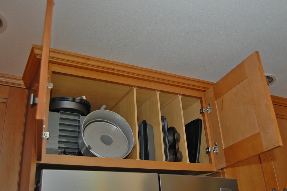 Inspiration for a small transitional l-shaped open concept kitchen remodel in Portland with an undermount sink, shaker cabinets, medium tone wood cabinets, quartz countertops, brown backsplash, glass tile backsplash, stainless steel appliances and a peninsula