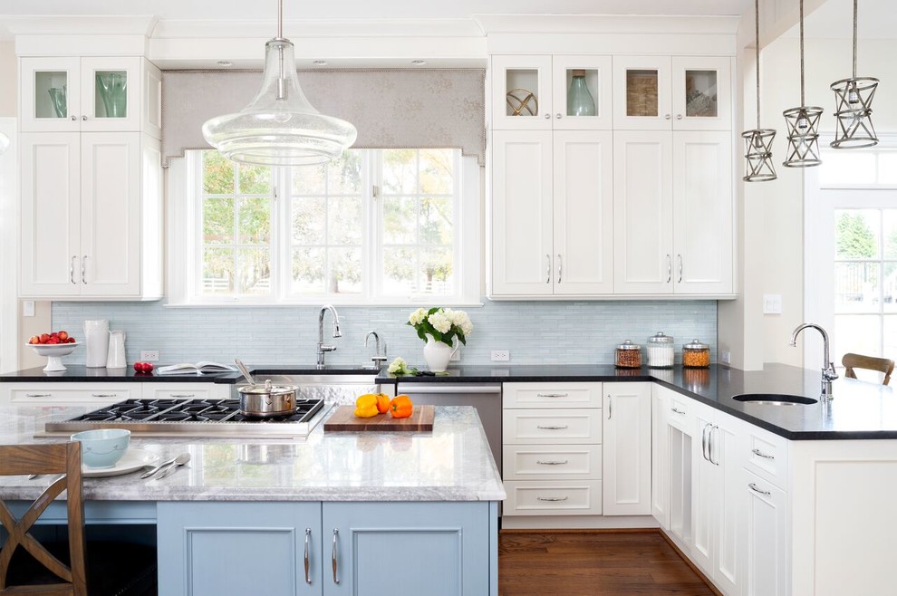 Design ideas for a mid-sized transitional l-shaped open plan kitchen in DC Metro with a farmhouse sink, beaded inset cabinets, white cabinets, limestone benchtops, blue splashback, matchstick tile splashback, stainless steel appliances, medium hardwood floors and with island.