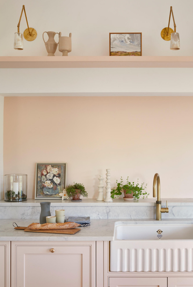 Design ideas for a large country grey and pink single-wall open plan kitchen in London with a belfast sink, shaker cabinets, pink cabinets, quartz worktops, pink splashback, black appliances, ceramic flooring, an island, multi-coloured floors, grey worktops and a vaulted ceiling.