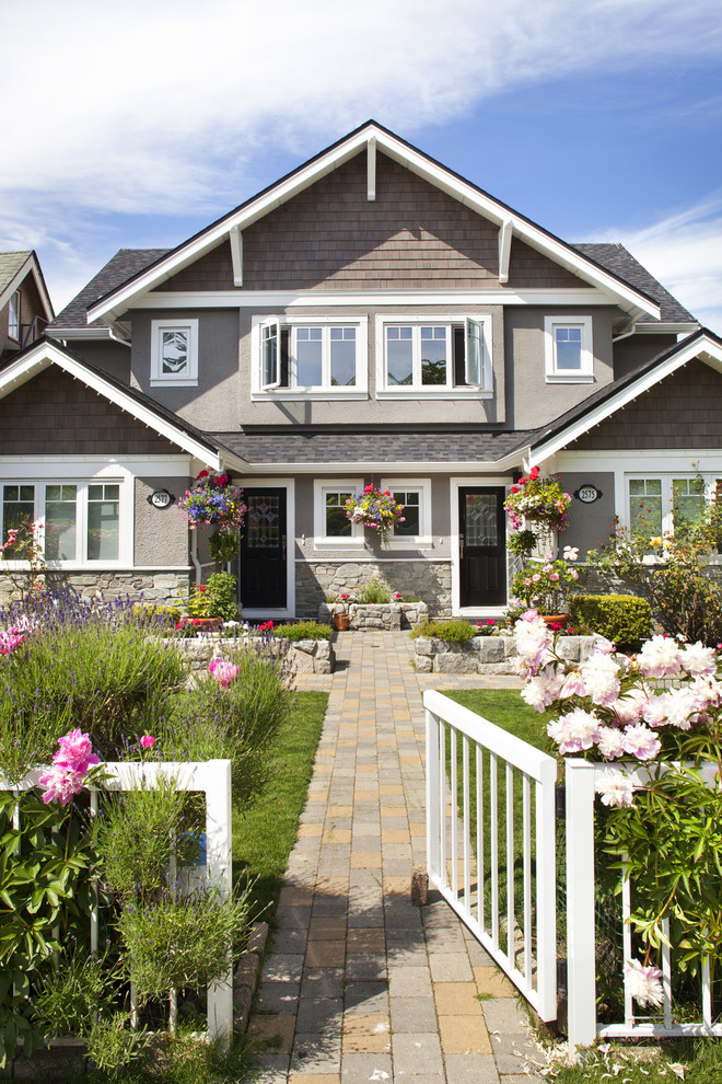 Inspiration for a mid-sized traditional two-storey stucco grey duplex exterior in Vancouver with a gable roof.