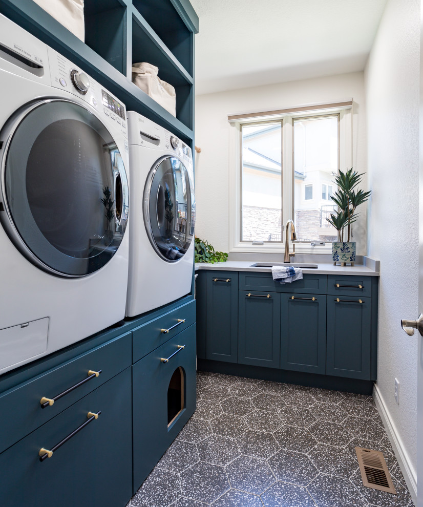 Dedicated laundry room - mid-sized transitional l-shaped porcelain tile and gray floor dedicated laundry room idea in Denver with an undermount sink, recessed-panel cabinets, green cabinets, quartz countertops, white walls, a side-by-side washer/dryer and white countertops