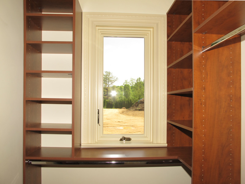 Small traditional gender-neutral walk-in wardrobe in New York with open cabinets and medium wood cabinets.