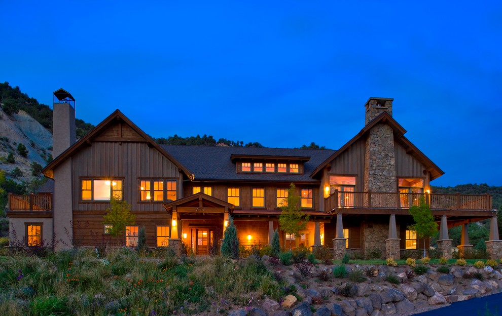 Photo of a large country two-storey brown exterior in Denver with wood siding.
