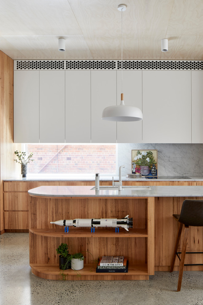 Photo of a large contemporary l-shaped eat-in kitchen in Melbourne with a double-bowl sink, flat-panel cabinets, medium wood cabinets, marble benchtops, white splashback, marble splashback, stainless steel appliances, terrazzo floors, with island, grey floor and white benchtop.