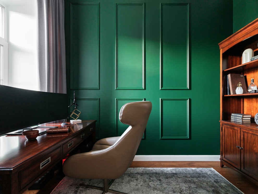 Kleines Klassisches Arbeitszimmer mit Arbeitsplatz, grüner Wandfarbe, braunem Holzboden, freistehendem Schreibtisch und braunem Boden in Sonstige