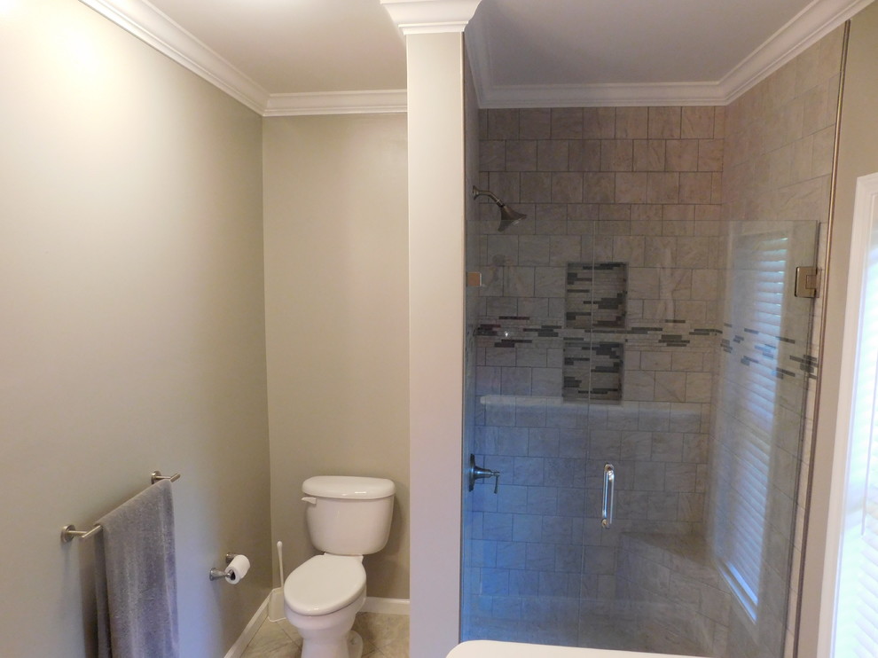 Large transitional master gray tile and ceramic tile ceramic tile corner bathtub photo with raised-panel cabinets, medium tone wood cabinets, a two-piece toilet, beige walls, an undermount sink and granite countertops
