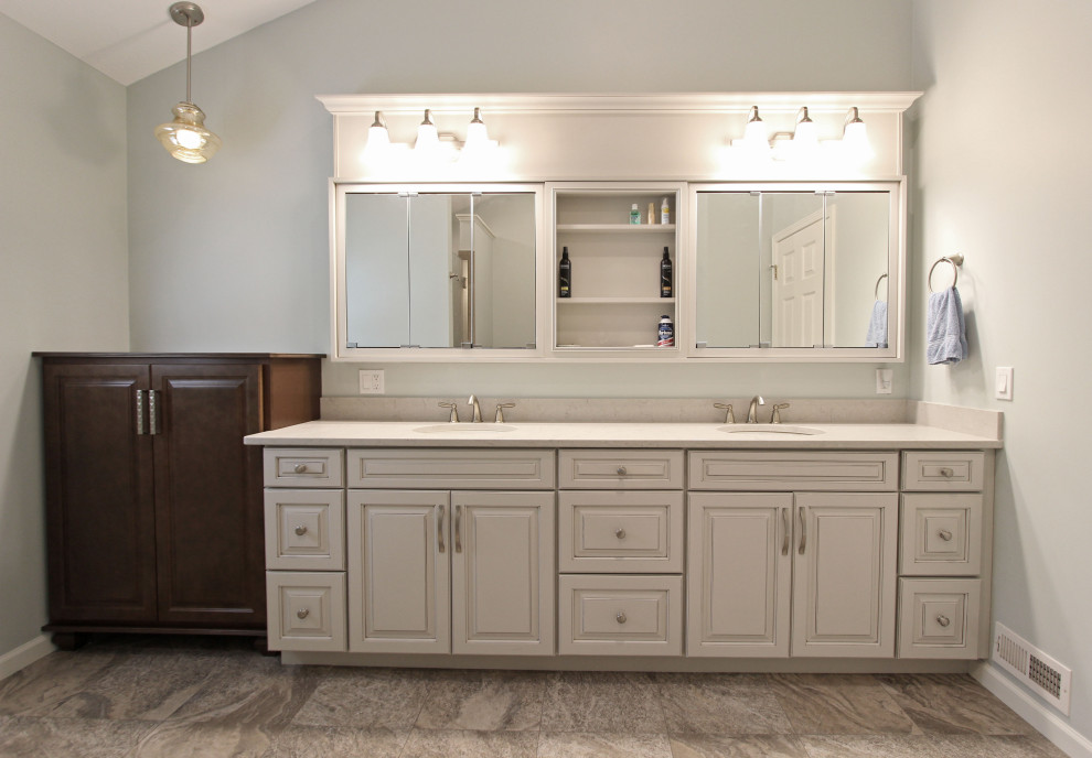 Mid-sized transitional master bathroom in Cleveland with raised-panel cabinets, grey cabinets, a corner shower, a two-piece toilet, cement tiles, an undermount sink, engineered quartz benchtops, beige floor, a hinged shower door and beige benchtops.