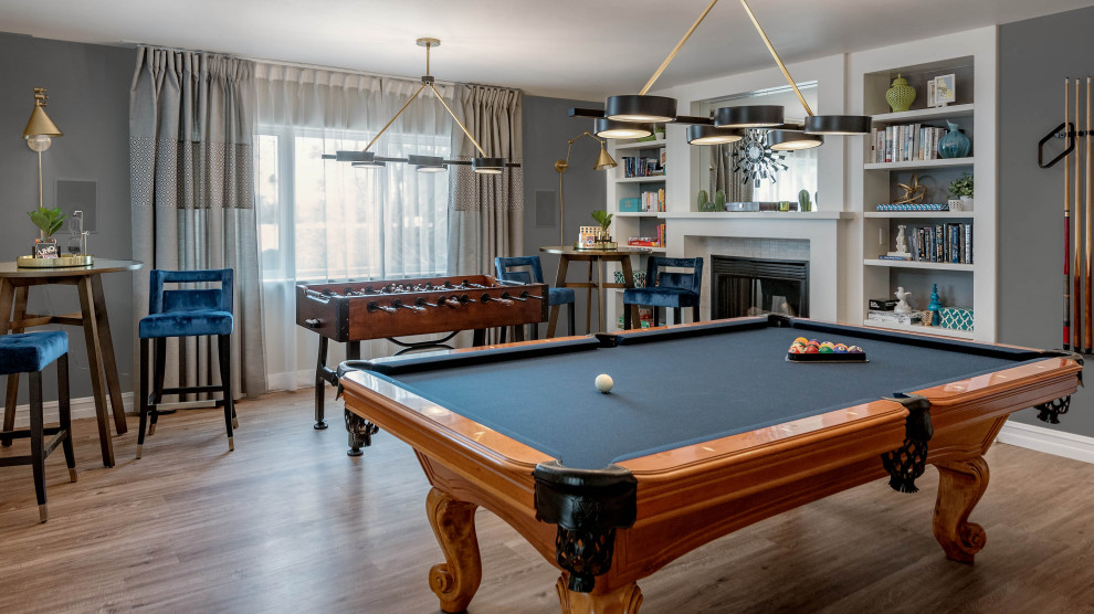 Game room - large transitional open concept vinyl floor and brown floor game room idea with gray walls, a standard fireplace and a tile fireplace