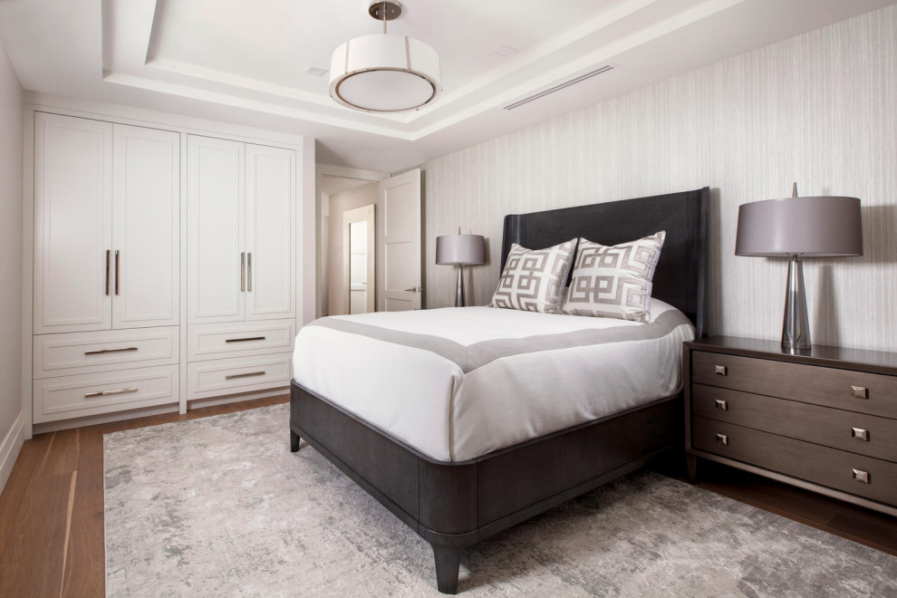 Photo of a mid-sized beach style guest bedroom in Miami with grey walls, medium hardwood floors, brown floor and wallpaper.