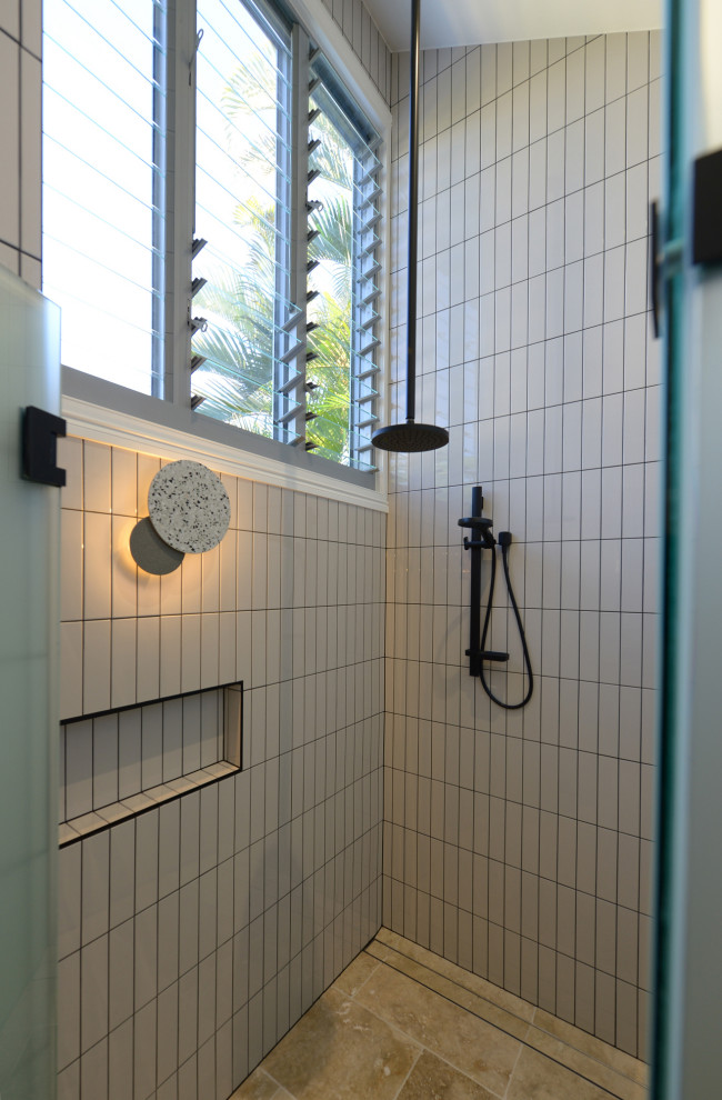 Идея дизайна: главная ванная комната среднего размера в морском стиле с душевой комнатой, белой плиткой, керамической плиткой, белыми стенами, полом из травертина, душем с распашными дверями и сводчатым потолком