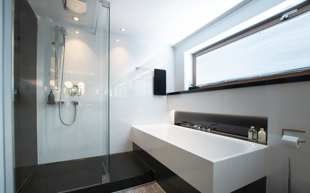 Exemple d'une salle de bain chic de taille moyenne avec des portes de placard blanches, une baignoire posée, une douche ouverte, un carrelage noir et blanc, un plan de toilette en granite, un plan de toilette noir, meuble simple vasque et meuble-lavabo encastré.