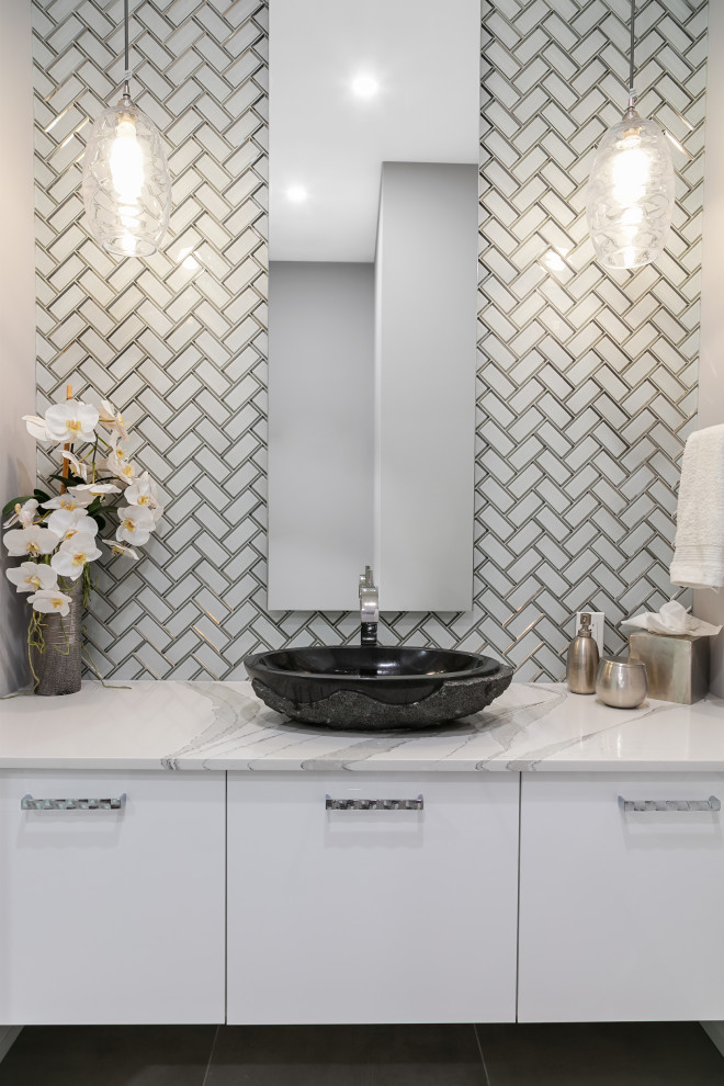 Inspiration for a mid-sized contemporary powder room in Tampa with flat-panel cabinets, white cabinets, a two-piece toilet, white tile, glass tile, grey walls, porcelain floors, a vessel sink, engineered quartz benchtops, grey floor, white benchtops and a floating vanity.