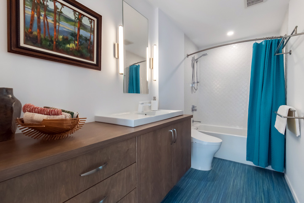 This is an example of a mid-sized midcentury bathroom in Phoenix with flat-panel cabinets, medium wood cabinets, an alcove tub, a shower/bathtub combo, a two-piece toilet, white tile, porcelain tile, white walls, linoleum floors, a drop-in sink, wood benchtops, a shower curtain, a single vanity and a floating vanity.