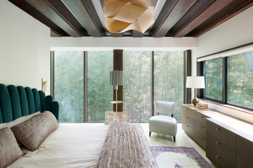 Ejemplo de dormitorio principal retro de tamaño medio sin chimenea con paredes blancas, suelo de madera clara y vigas vistas