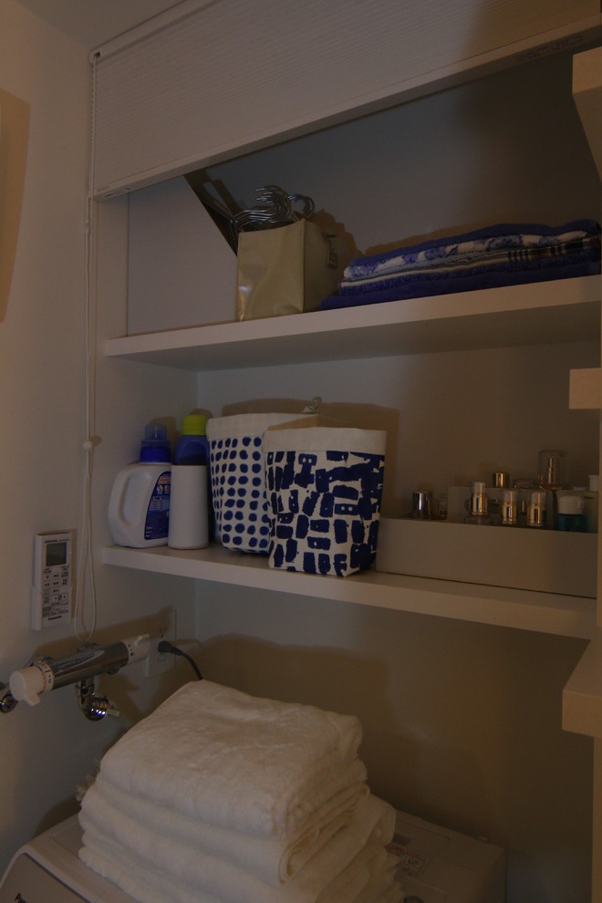 This is an example of a mid-sized modern utility room in Other with open cabinets, white walls, linoleum floors and white floor.