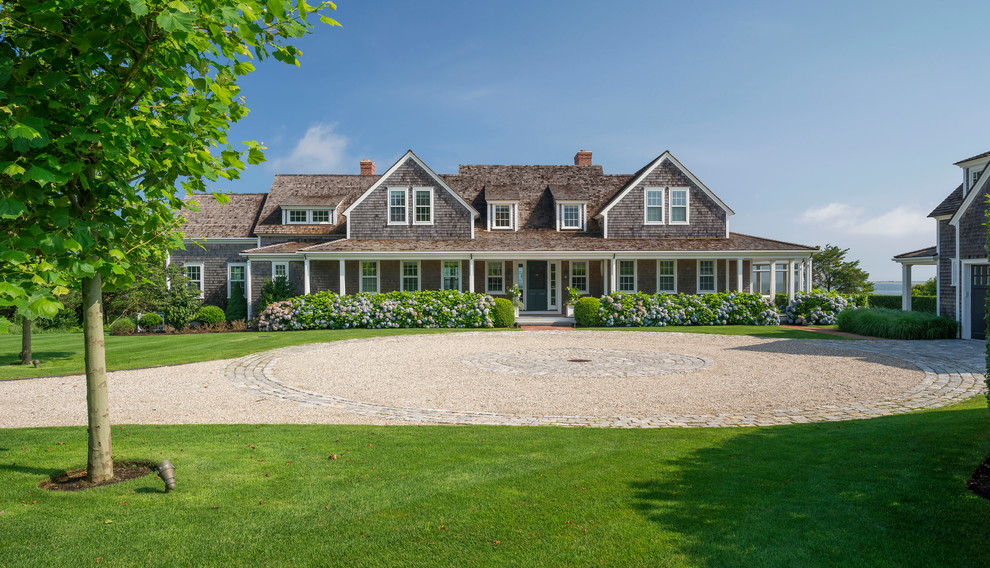 Inspiration for an expansive beach style front yard full sun driveway in Boston with natural stone pavers.