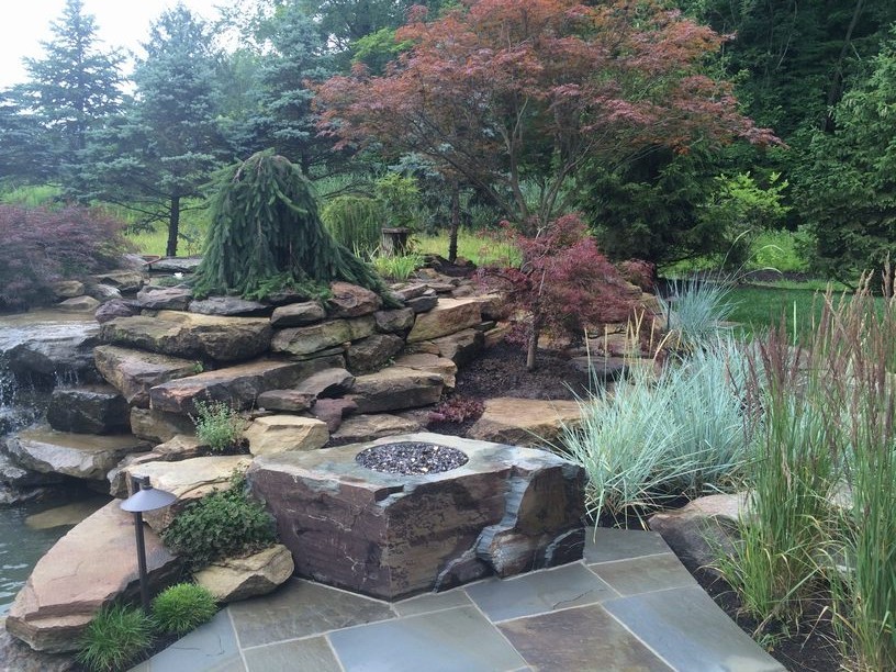 Inspiration for a large asian backyard patio in Cleveland with natural stone pavers and a pergola.