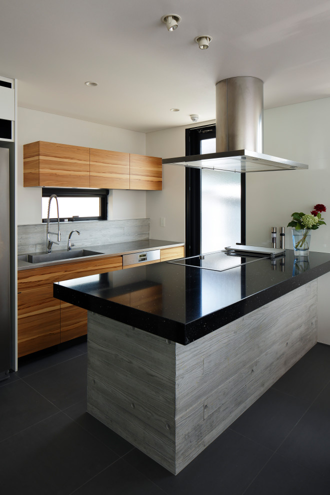 Photo of a contemporary galley eat-in kitchen in Other with an integrated sink, flat-panel cabinets, brown cabinets, solid surface benchtops, white splashback, stainless steel appliances, porcelain floors, with island, grey floor and black benchtop.
