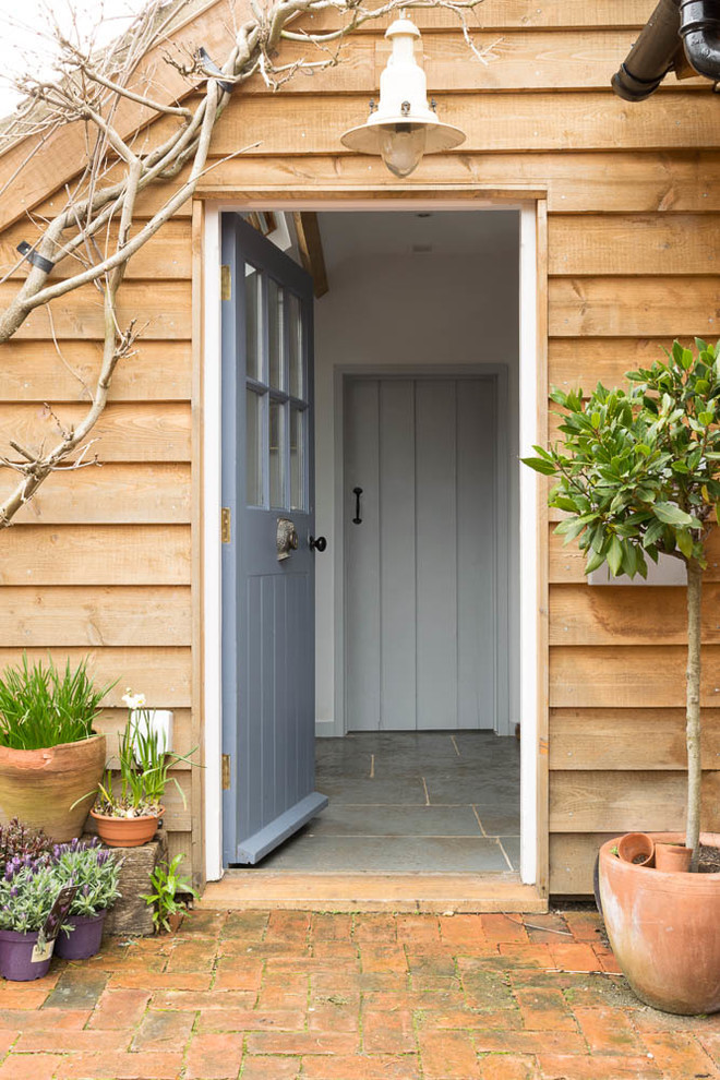 Photo of a mid-sized country front door in Hampshire with limestone floors, a blue front door and grey floor.