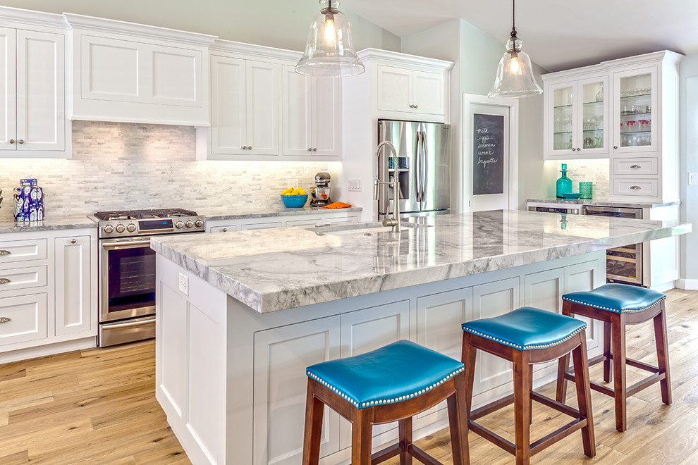 Kitchen - mid-sized transitional u-shaped medium tone wood floor kitchen idea in Phoenix with an undermount sink, shaker cabinets, white cabinets, quartzite countertops, multicolored backsplash, mosaic tile backsplash, stainless steel appliances, an island and white countertops