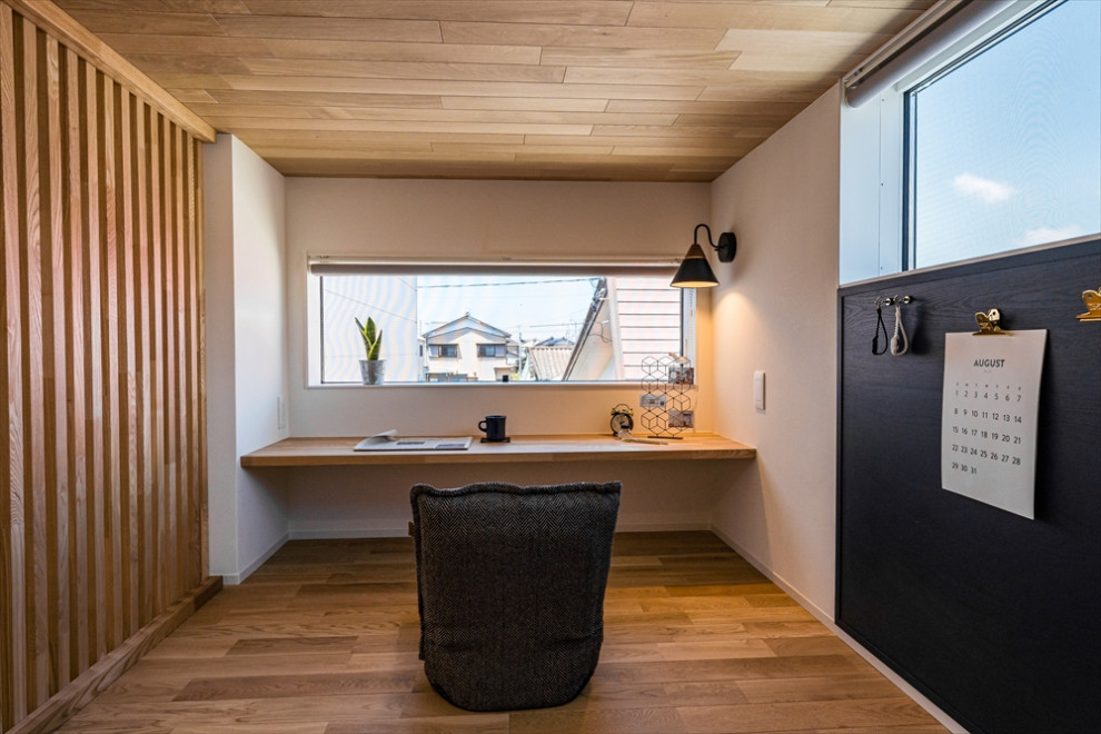 Réalisation d'un bureau minimaliste avec un mur blanc, un sol en bois brun, un bureau intégré, un plafond en bois et du papier peint.