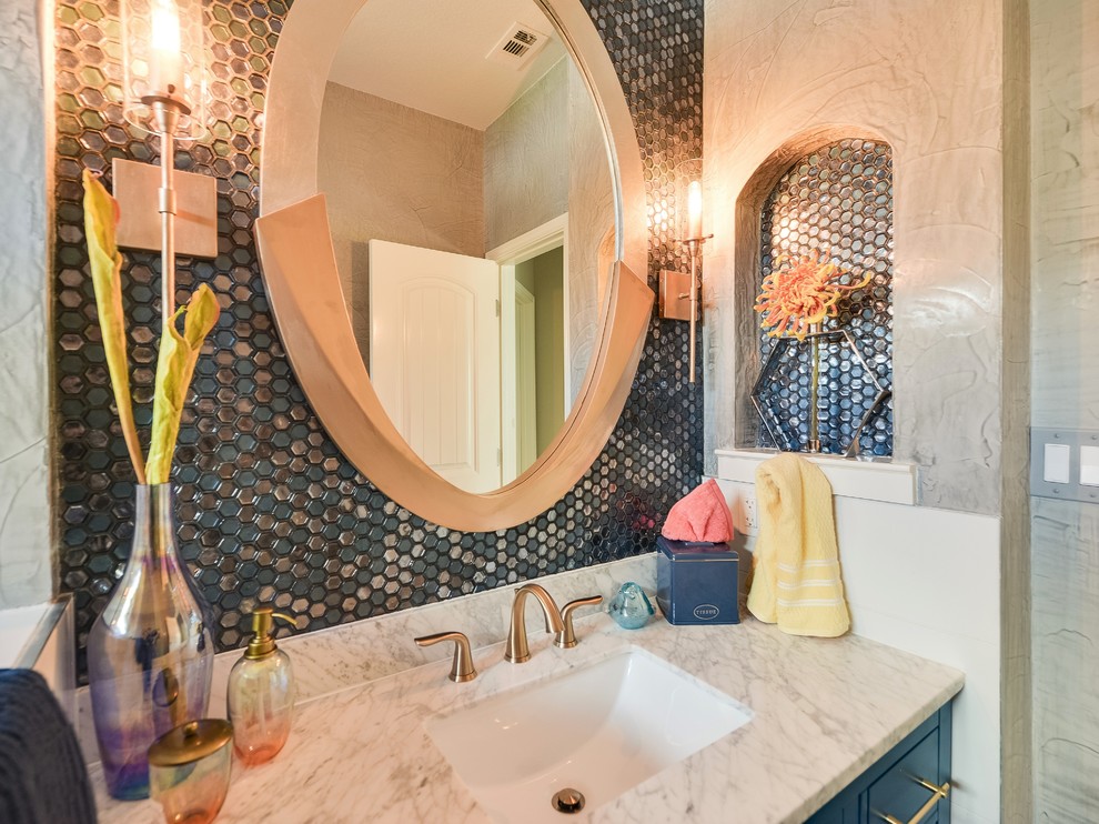 This is an example of a small modern bathroom in Austin with shaker cabinets, blue cabinets, an alcove tub, a shower/bathtub combo, blue tile, mosaic tile, ceramic floors, an undermount sink, marble benchtops, multi-coloured floor, a hinged shower door and white benchtops.