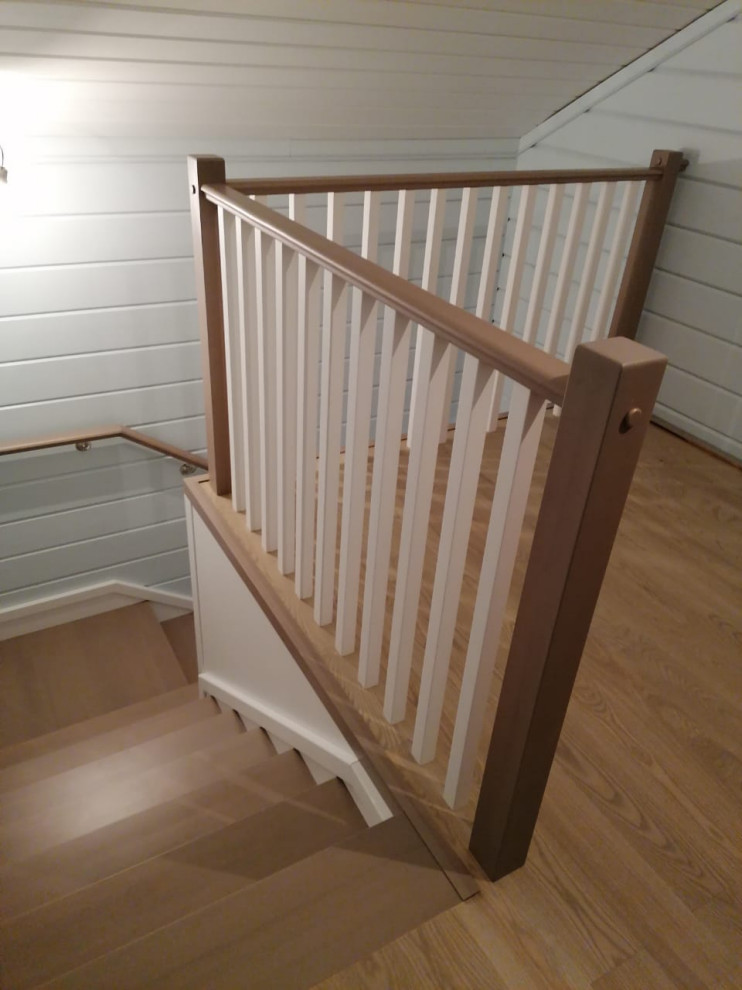 Cette image montre un petit escalier traditionnel en L avec des marches en bois, des contremarches en bois, un garde-corps en bois et du lambris de bois.