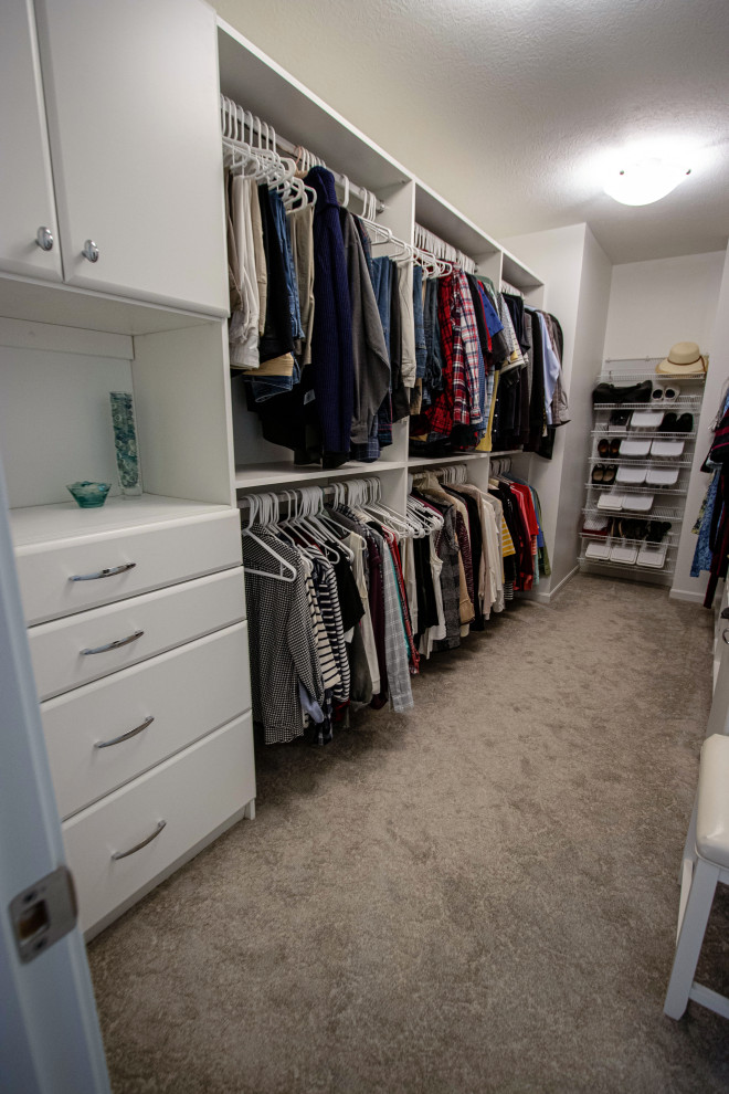 Mid-sized transitional gender-neutral walk-in wardrobe in Cleveland with carpet and beige floor.