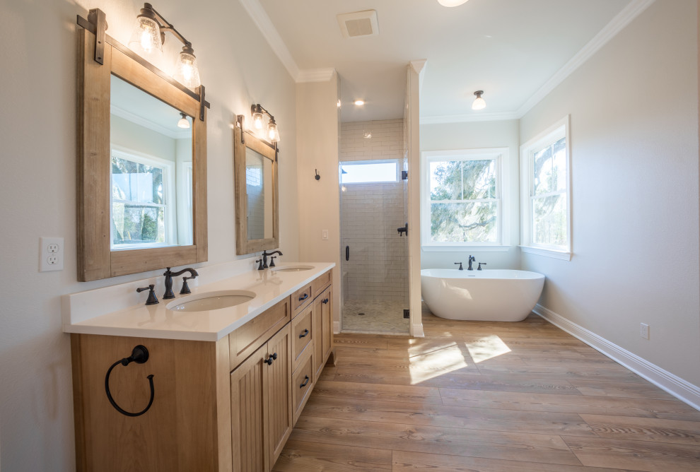 Inspiration for a mid-sized country master bathroom with beaded inset cabinets, brown cabinets, a freestanding tub, a curbless shower, a two-piece toilet, white tile, glass tile, beige walls, vinyl floors, an undermount sink, quartzite benchtops, brown floor, an open shower, white benchtops, an enclosed toilet, a double vanity and a built-in vanity.