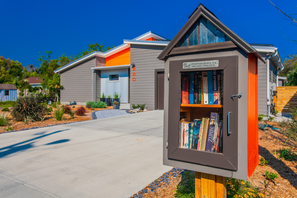 Inspiration for a mid-sized contemporary one-storey grey house exterior in New Orleans with concrete fiberboard siding, a shed roof and a metal roof.