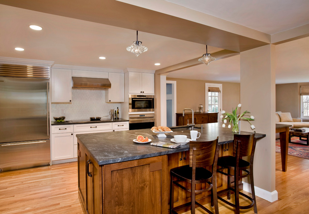 Inspiration for a transitional galley eat-in kitchen remodel in Boston with an undermount sink, shaker cabinets, white cabinets, granite countertops, white backsplash and stainless steel appliances