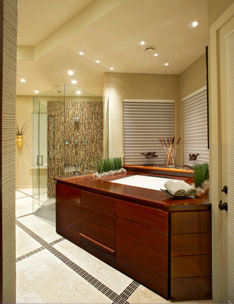 Design ideas for a large asian master bathroom in Dallas with flat-panel cabinets, dark wood cabinets, a japanese tub, a curbless shower, travertine floors, a vessel sink, wood benchtops, beige walls, beige floor and a hinged shower door.