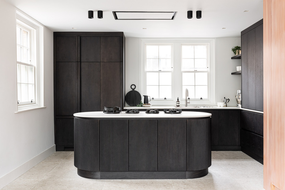 This is an example of a contemporary l-shaped kitchen in London with flat-panel cabinets, dark wood cabinets, with island, grey floor and white benchtop.