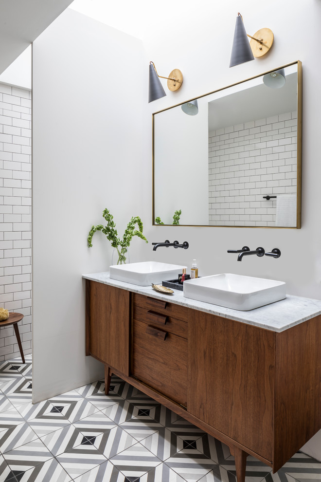 This is an example of a scandinavian master bathroom in New York with dark wood cabinets, white tile, subway tile, white walls, cement tiles, a vessel sink, multi-coloured floor, grey benchtops and flat-panel cabinets.