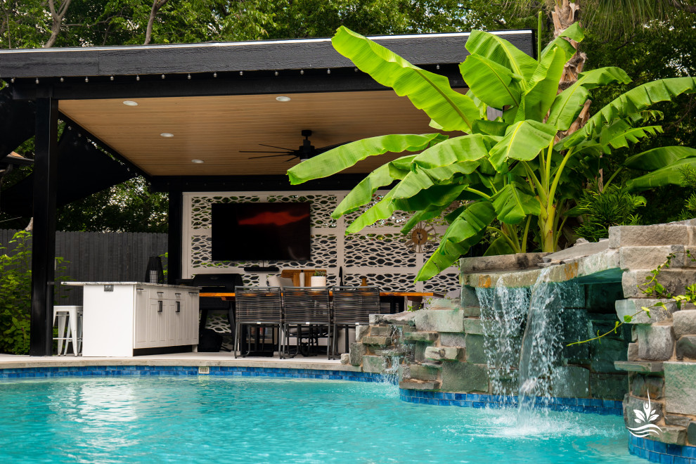 Foto di un'ampia piscina naturale etnica personalizzata dietro casa con pavimentazioni in pietra naturale