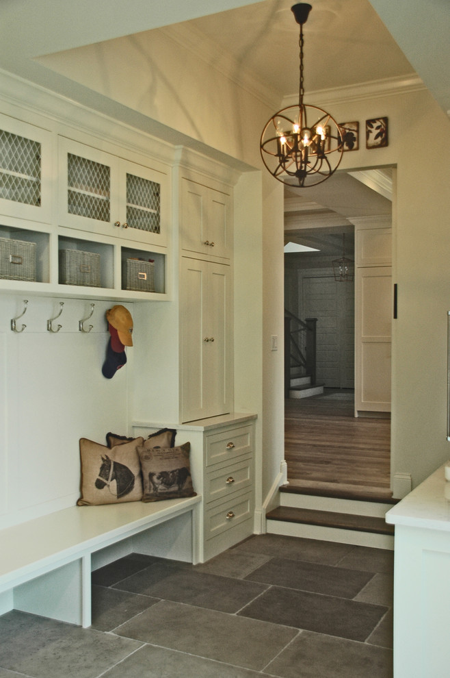 This is an example of a large country mudroom in Chicago with white walls and slate floors.