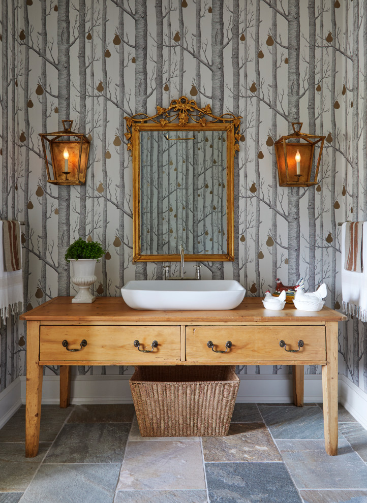 This is an example of a country bathroom in Other with distressed cabinets, multi-coloured walls, slate floors, a vessel sink, wood benchtops, multi-coloured floor, brown benchtops, a freestanding vanity, wallpaper and flat-panel cabinets.