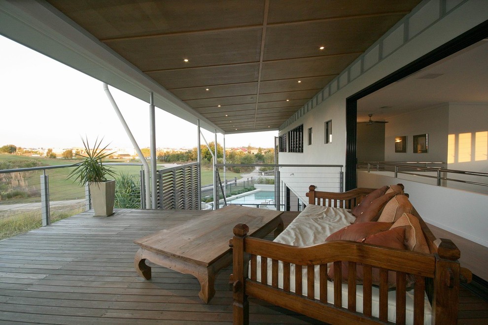 This is an example of a large contemporary side yard deck in Sunshine Coast with a roof extension.