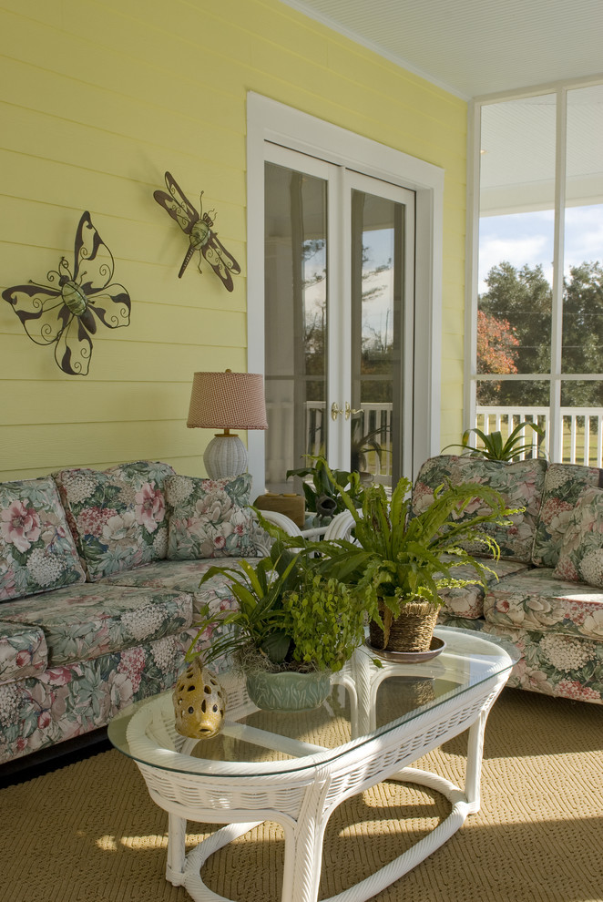 Photo of a large traditional side yard screened-in verandah in New Orleans with a roof extension.