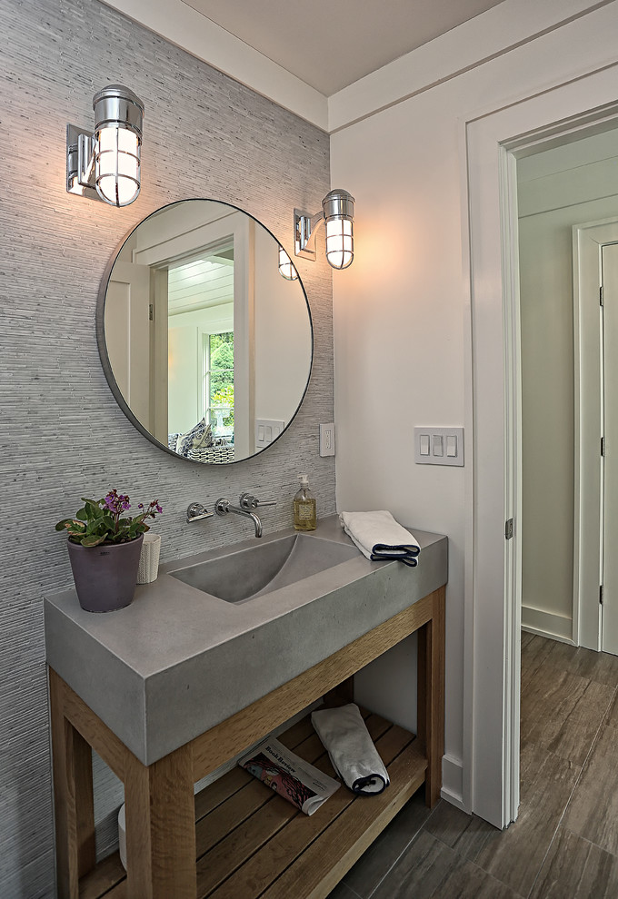 Design ideas for a mid-sized modern powder room in New York with furniture-like cabinets, distressed cabinets, grey walls, medium hardwood floors, an integrated sink and concrete benchtops.