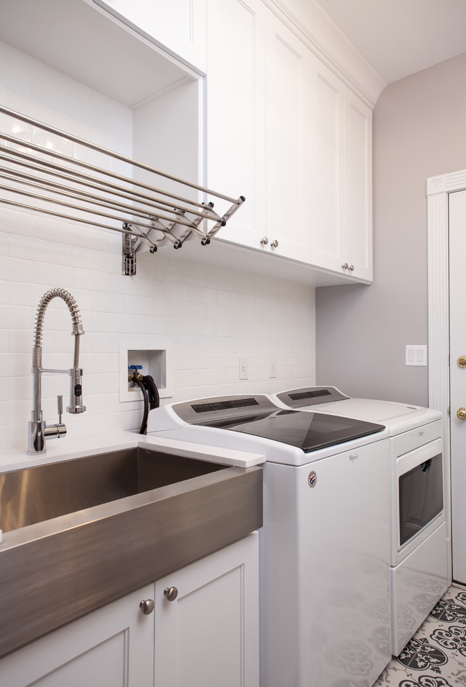 Photo of a mid-sized traditional galley utility room in Chicago with a single-bowl sink, shaker cabinets, white cabinets, quartz benchtops, grey walls, porcelain floors, a side-by-side washer and dryer, multi-coloured floor and white benchtop.