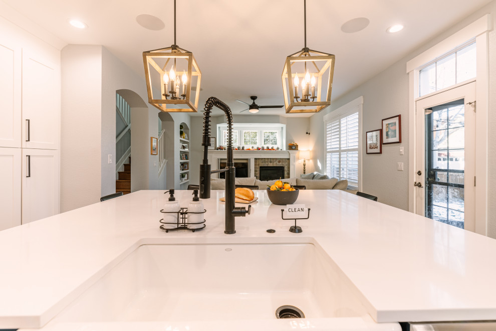 Inspiration for a large country l-shaped open plan kitchen in Denver with a single-bowl sink, shaker cabinets, blue cabinets, quartzite benchtops, white splashback, ceramic splashback, stainless steel appliances, vinyl floors, with island, beige floor and white benchtop.