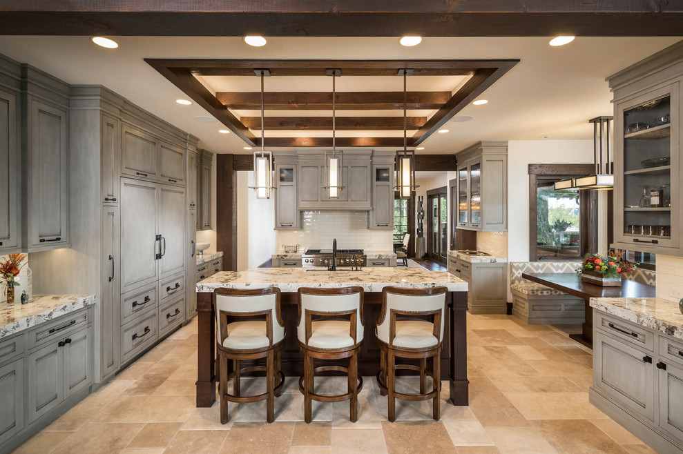 Inspiration for a rustic u-shaped beige floor and exposed beam kitchen remodel with an undermount sink, shaker cabinets, white backsplash, subway tile backsplash, stainless steel appliances, an island and multicolored countertops