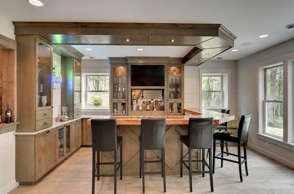 Inspiration for a transitional u-shaped seated home bar in Minneapolis with light hardwood floors, shaker cabinets, medium wood cabinets and granite benchtops.